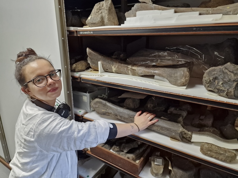 Yay standing in front of a cabinet of large fossils